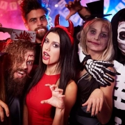 Guests dressed in Halloween costumes posing and celebrating together at a themed private party.