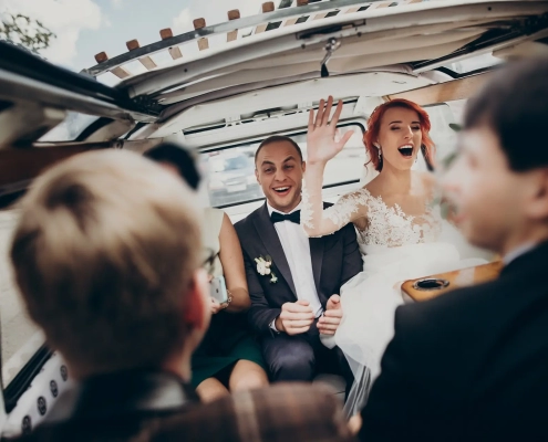 stylish happy bride and groom having fun in a limo
