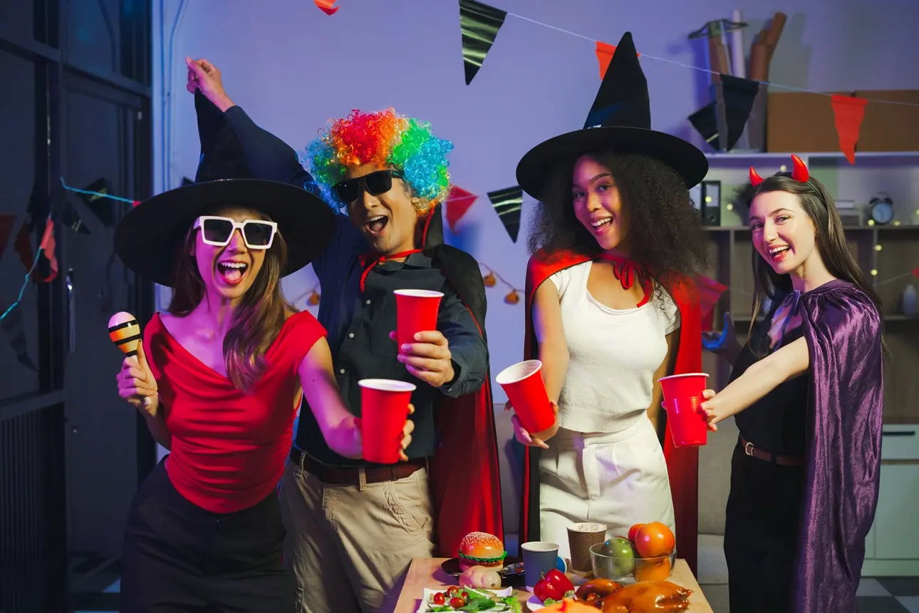 Dinner and group of people celebrating together at Halloween party